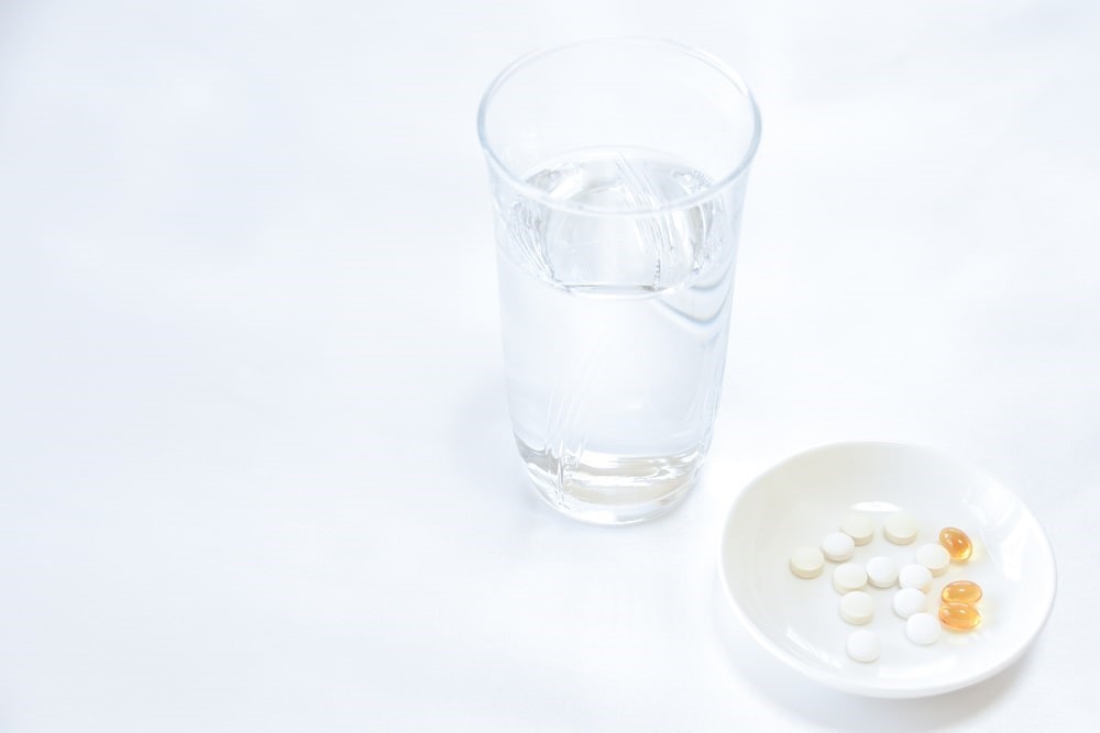 Vaso de agua con pastillas