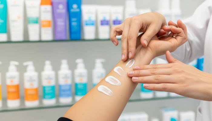 Farmacéutico probando diferentes filtros fotoprotección en la piel de un paciente