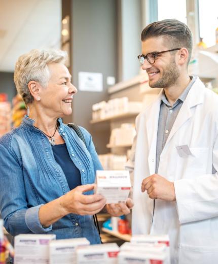 Farmacéutico hablando y asesorando a un paciente en la farmacia