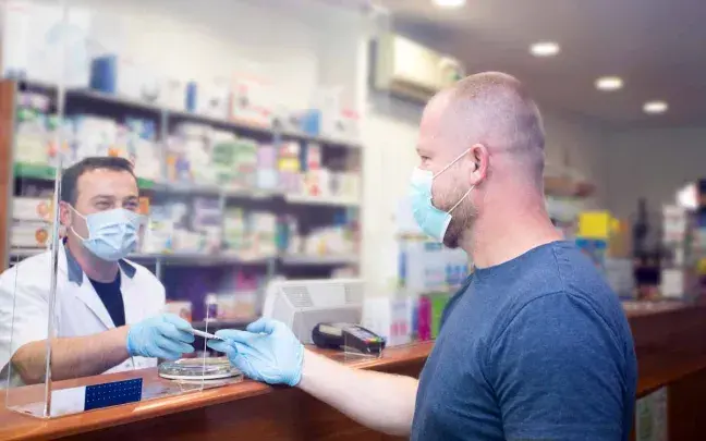 farmaceutico-entrega-medicamento-a-paciente dispensacion de medicamento en la farmacia
