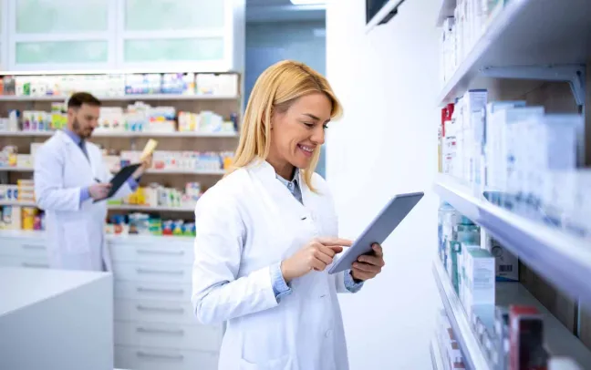 Farmacéutica revisa la tablet en la farmacia farmaceutica-con-tablet-en-la-mano