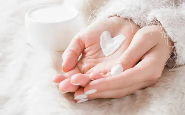 Manos con crema en forma de corazón manos-con-crema