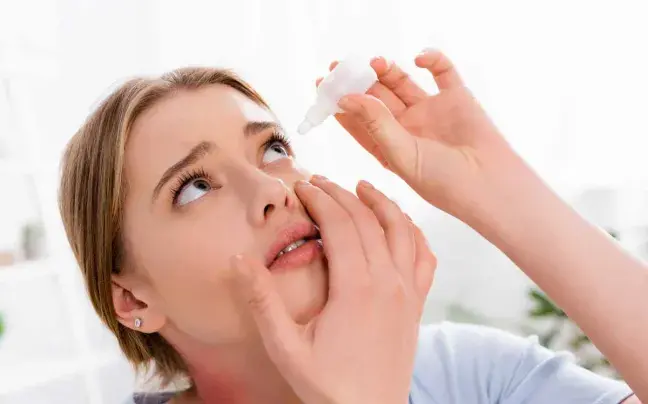 Persona con colirio colirio-para-los-ojos