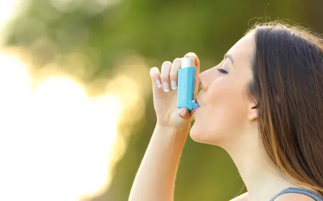 Mujer con asma usa el inhalador mujer-con-inhalador