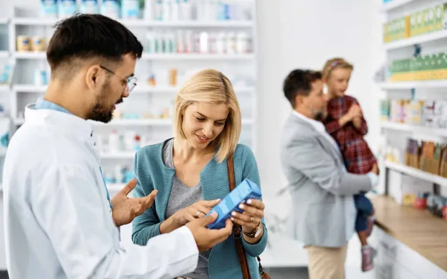 Farmacéutico enseña un producto a una paciente farmaceutico-muestra-producto-a-paciente