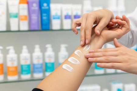 Farmacéutico probando diferentes filtros fotoprotección en la piel de un paciente