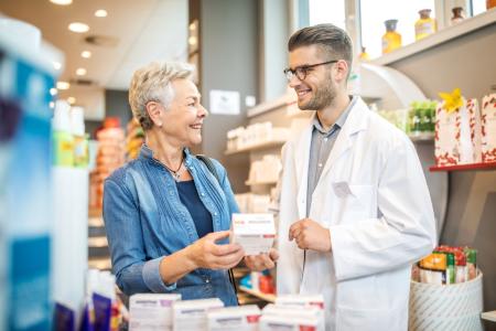 Farmacéutico hablando y asesorando a un paciente en la farmacia